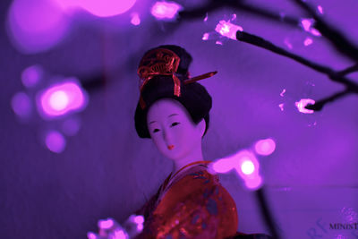 Doll in illuminated purple room