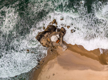 Directly above shot of waves rushing on shore at beach