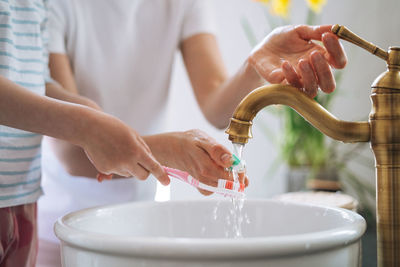 Young mother woman with little girl daughter in pajamas brushing their teeth in the morning at home