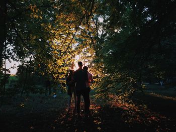 Friends standing in forest during autumn