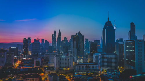 Illuminated buildings in city against sky