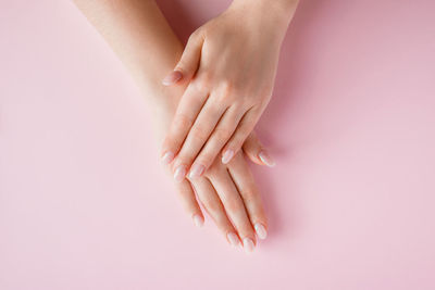 Beautiful female hands on a pink background. spa and body care concept. image for advertising.