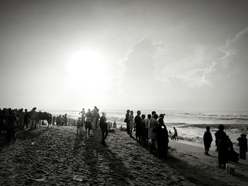 People at beach against sky