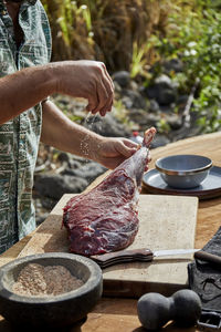 Chef seasoning local venison leg for barbecue