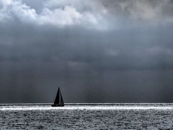 Sailboat sailing on sea against sky