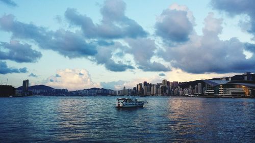 Boat in river against cloudy sky