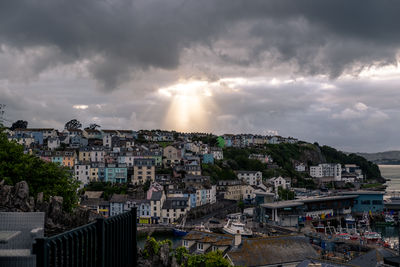 High angle view of buildings in city against storm clouds