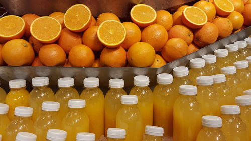 High angle view of fresh oranges and juice bottles at store