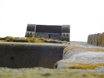 Close-up of stone wall on beach against sky