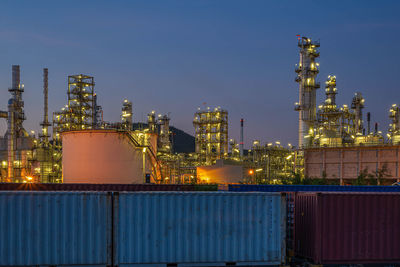 Illuminated factory against sky at night