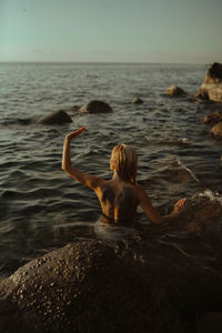 Rear view of woman swimming in sea