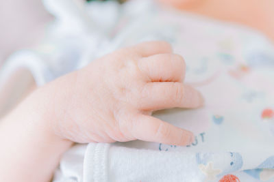 Close-up of baby hand on bed