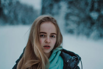 Portrait of young woman standing on snow
