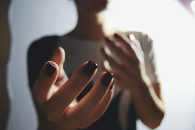 Midsection of woman gesturing at home