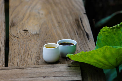 Close-up of coffee cup and leaves on table