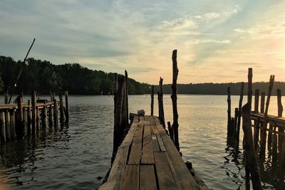 Pier in sea at sunset