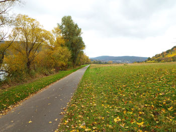 Road amidst field against sky