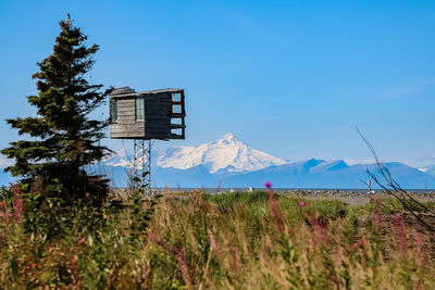 Built structure on field against clear blue sky