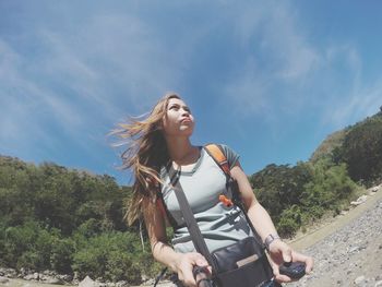 Woman with bicycle against sky