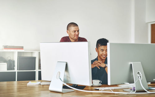 Happy man working on computer at office