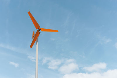 Low angle view of windmill against blue sky