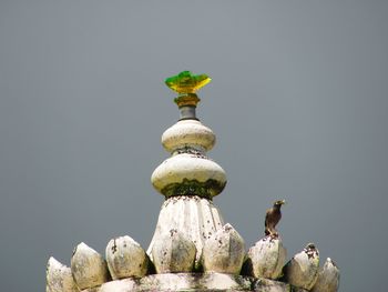 Statue of birds perching against clear sky