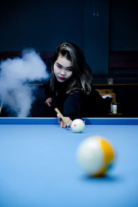 Young woman playing pool