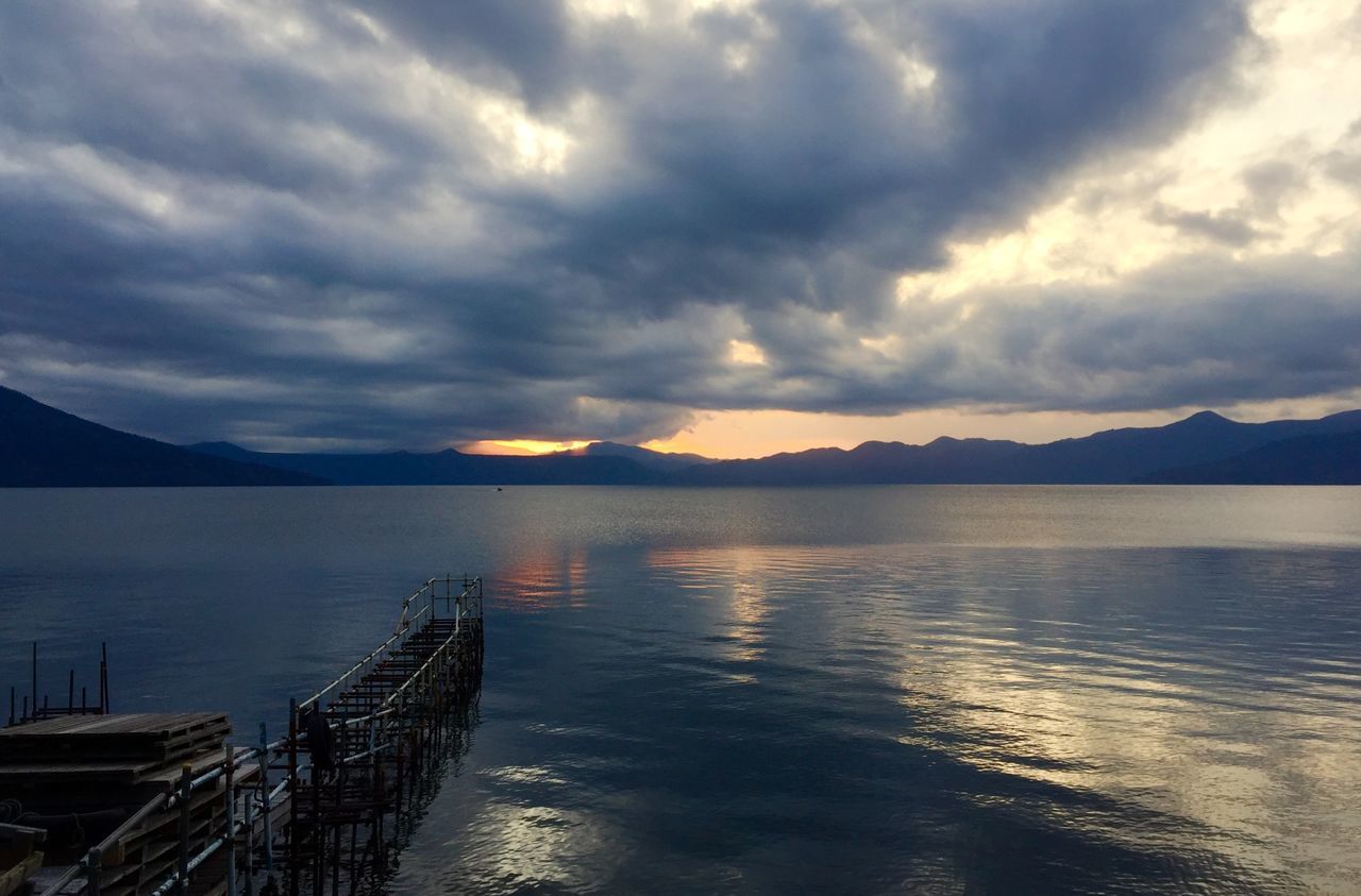 water, sky, tranquil scene, scenics, tranquility, beauty in nature, cloud - sky, mountain, sea, sunset, nature, lake, cloudy, cloud, idyllic, pier, reflection, mountain range, calm, outdoors