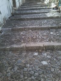 Narrow stairs leading to stone wall