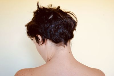 Rear view of senior woman against white background