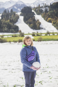 Blonde girl makes a snowman in slovenia in the alps