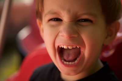 Close-up portrait of boy shouting outdoors