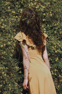 Rear view of woman standing against plants