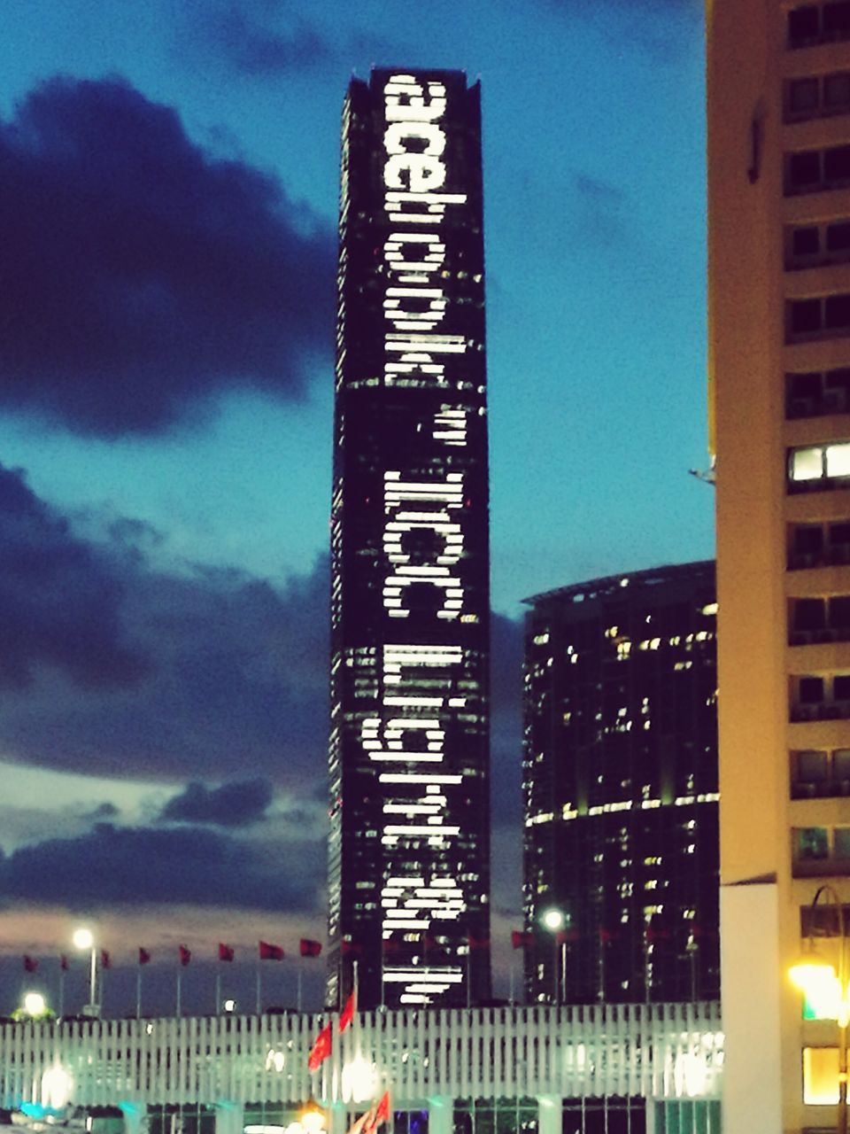 LOW ANGLE VIEW OF ILLUMINATED SKYSCRAPER AGAINST SKY