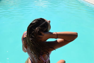 Rear view of woman swimming in pool