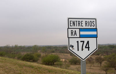 Information sign on road against sky