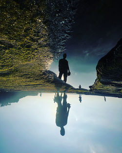 Rear view of man walking on lake