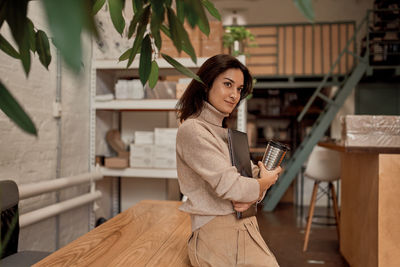 Businesswoman looking away while standing in cafe