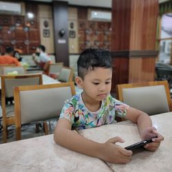 Girl looking away while sitting on laptop