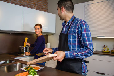 Man and woman standing in kitchen at home