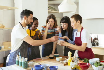 Friends tasting food in a cooking workshop