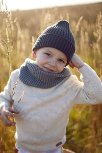 Fashionable boy child stand on a chair in autumn on the field