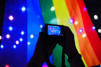 Low angle view of hand holding illuminated smart phone at night