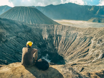 Man is sitting on the edge of the volcano 