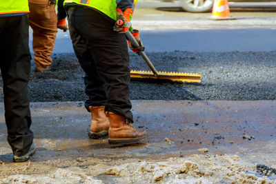 Low section of construction worker working on road