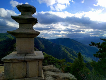 Cross at temple against sky