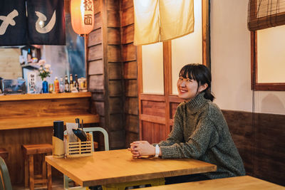 Portrait of smiling woman sitting at restaurant