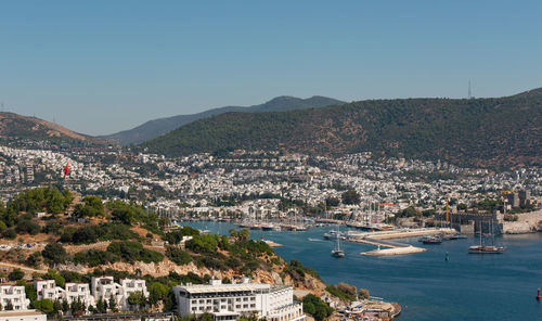 Aerial view of city by sea against clear sky