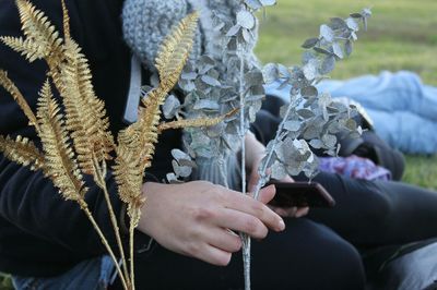 Midsection of person holding artificial flowers