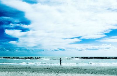 Man standing on beach against sky